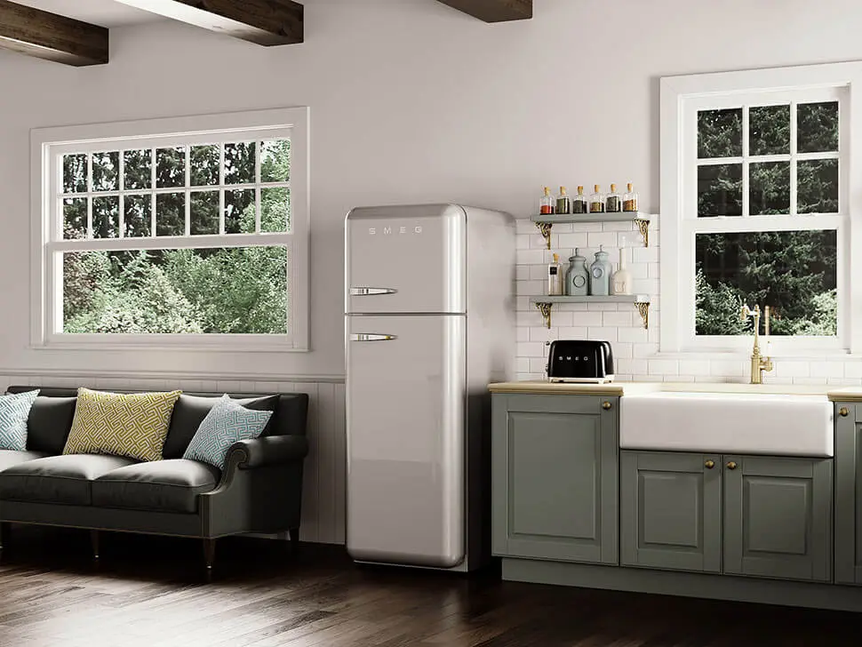 Srebrna lodówka SMEG w stylu retro w eleganckiej kuchni z zielonymi szafkami i dużym zlewem ceramicznym